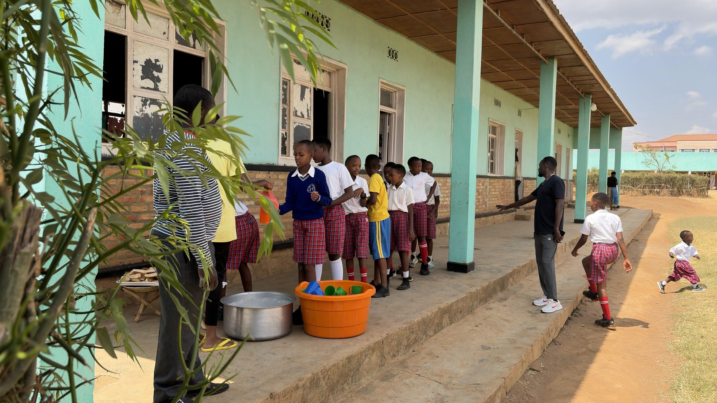 Children at a basin on the veranda of the school building