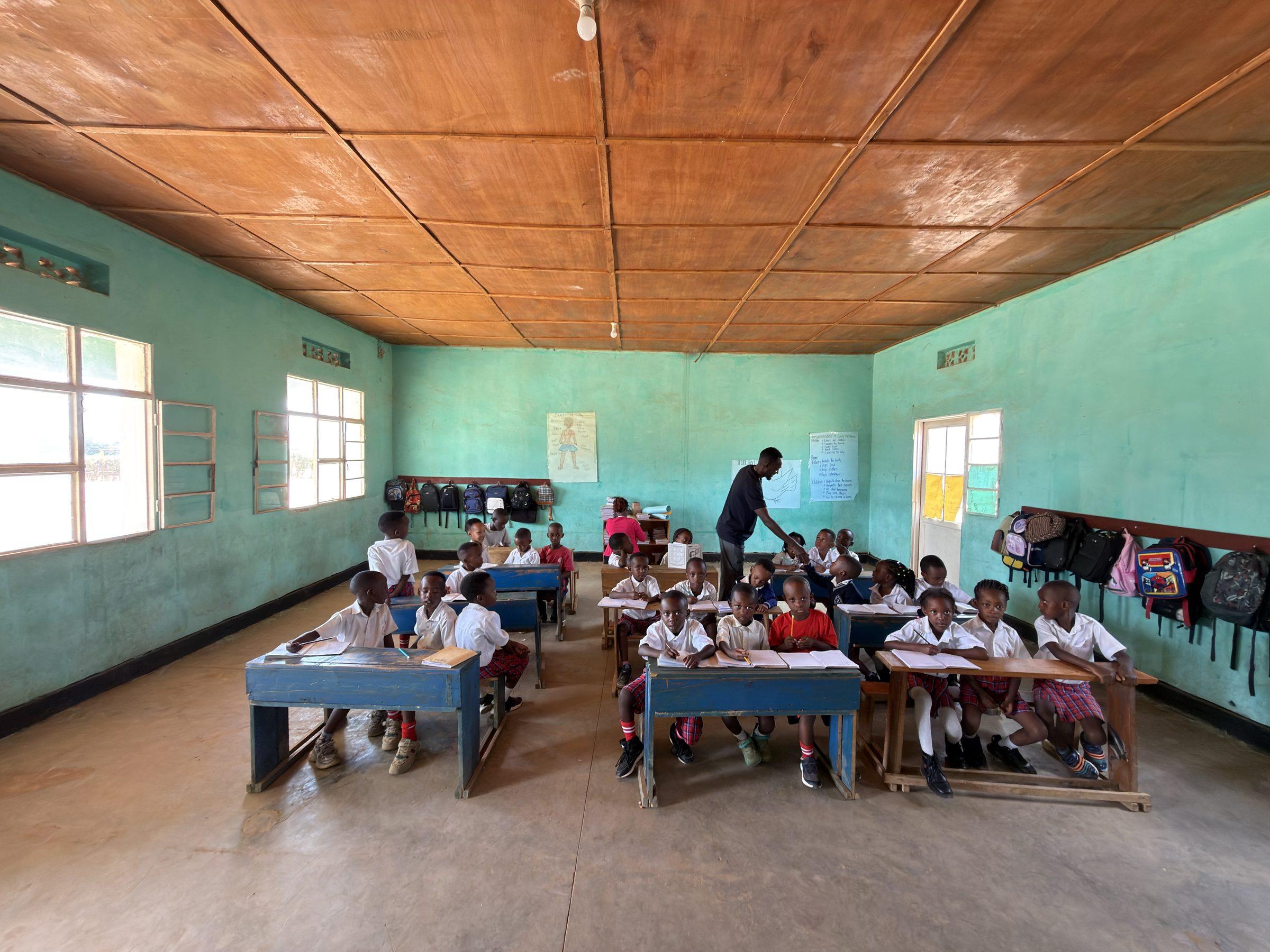 Rows of blue desks with pupils, seen from the classroom doorway