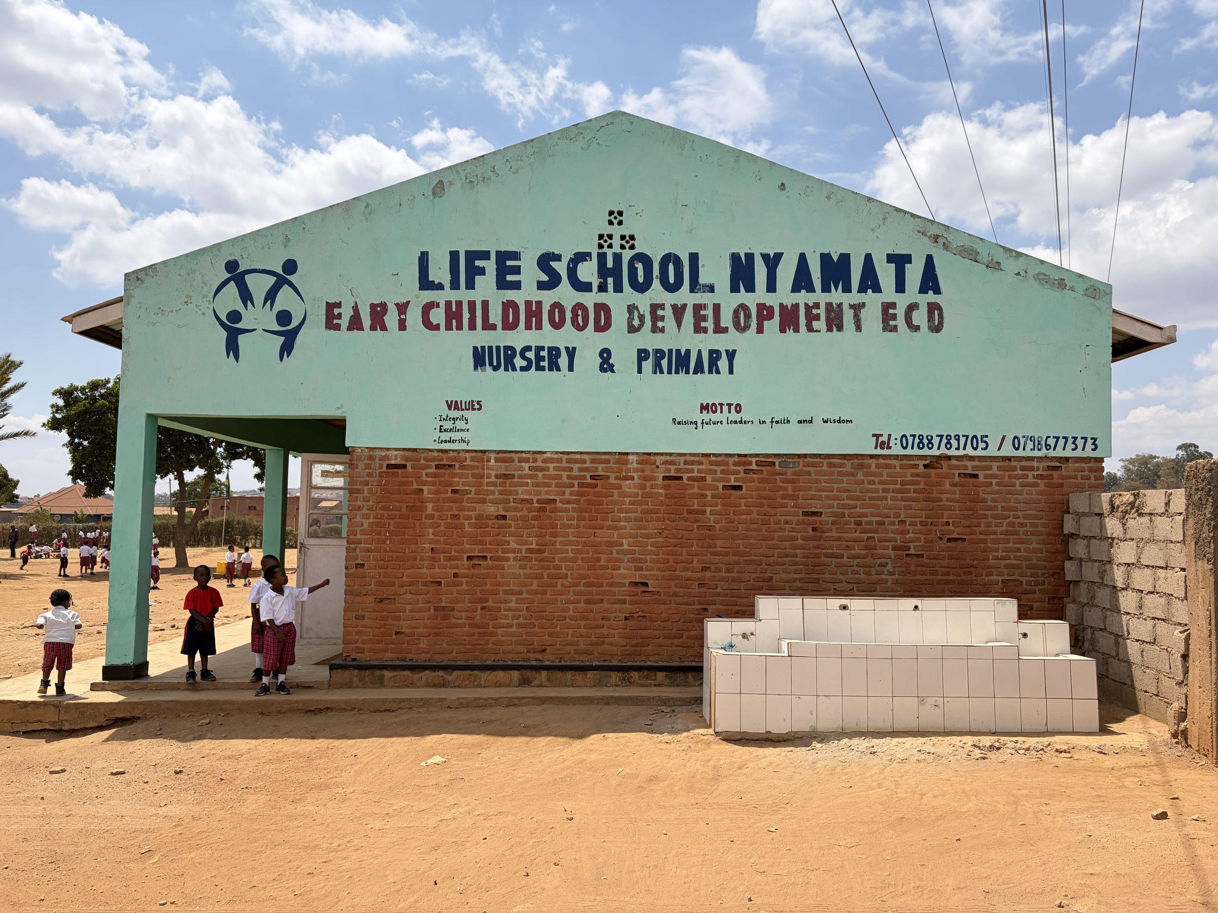 The painted gable sign reading Life School Nyamata, Early Childhood Development, Nursery and Primary